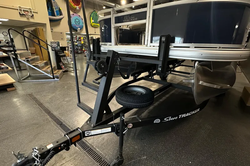 Slide: The Image of 2026 Sun Tracker Bass Buggy 18 DLX on trailer in showroom setting. - 48