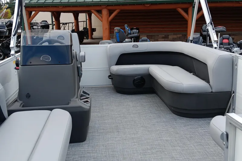 Slide: The Image of 2026 Sun Tracker Party Barge 16 DLX interior with gray seating and helm. - 2