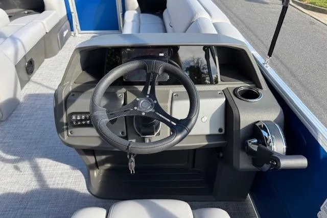 Slide: The Image of 2026 Sun Tracker Party Barge 20 DLX steering console with modern controls and seating. - 14