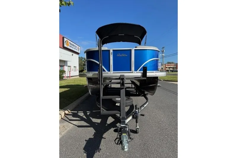 Slide: The Image of 2026 Sun Tracker Party Barge 20 DLX pontoon boat on trailer, parked outdoors. - 2
