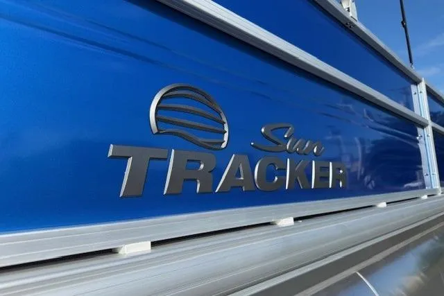Slide: The Image of 2026 Sun Tracker Party Barge 20 DLX logo on blue boat exterior. - 4