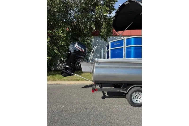 Slide: The Image of 2026 Sun Tracker Party Barge 20 DLX with Mercury outboard motor, parked outdoors. - 6