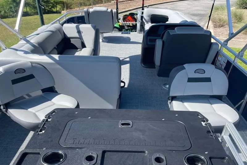 Slide: The Image of 2026 Sun Tracker SportFish 20 DLX pontoon boat interior with gray seating and fishing amenities. - 2