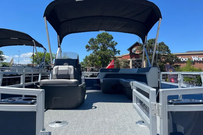 Slide: The Image of 2026 Sun Tracker Bass Buggy 16 XL Select pontoon boat with seating and canopy under blue sky. - 6