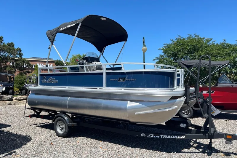 The Image of 2026 Sun Tracker Bass Buggy 16 XL Select pontoon boat on trailer, sunny day. - 0