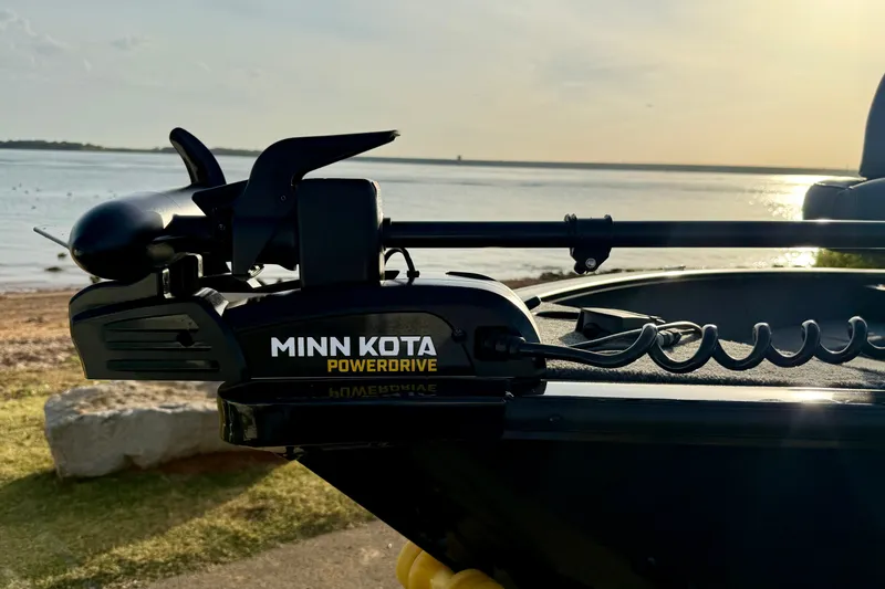 Slide: The Image of Minn Kota PowerDrive on 2026 Tracker Super Guide V-16 T boat by a serene lake. - 14