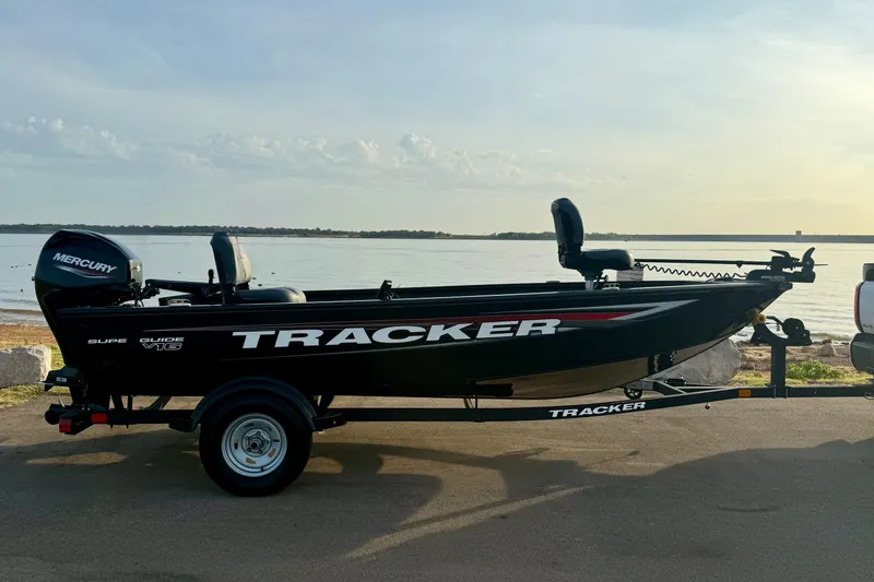 The Image of 2026 Tracker Super Guide V-16 T boat on trailer by a lake. - 0