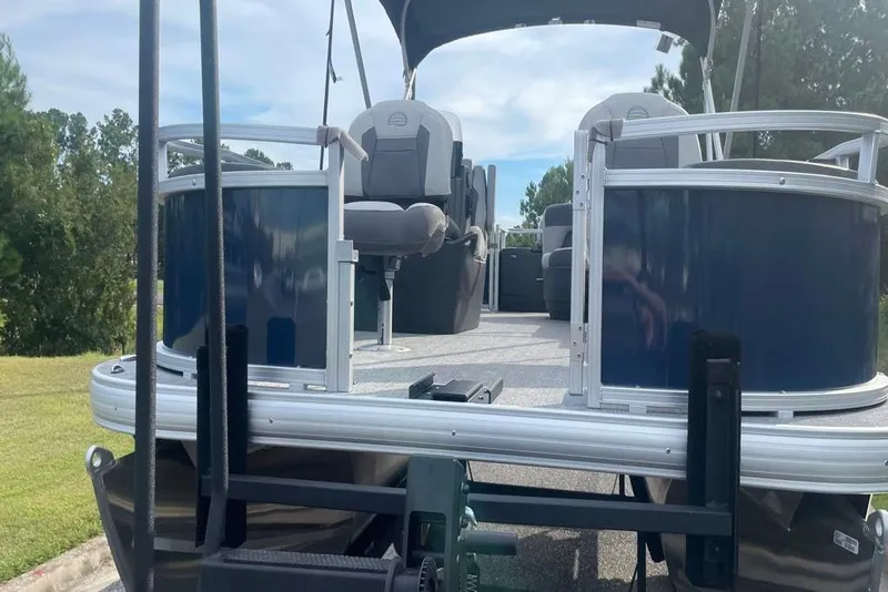 Slide: The Image of 2026 Sun Tracker Bass Buggy 18 DLX pontoon boat on trailer, outdoor setting. - 2