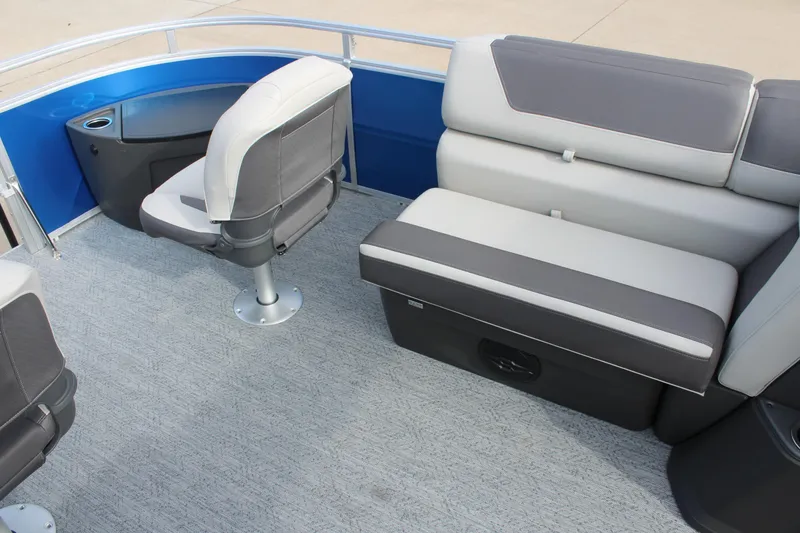 Slide: The Image of 2026 Sun Tracker Fishin' Barge 20 DLX interior with gray seating and blue accents. - 10
