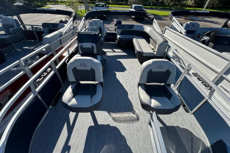 Slide: The Image of 2026 Sun Tracker Bass Buggy 16 XL Select pontoon boat interior with seating and steering console. - 2