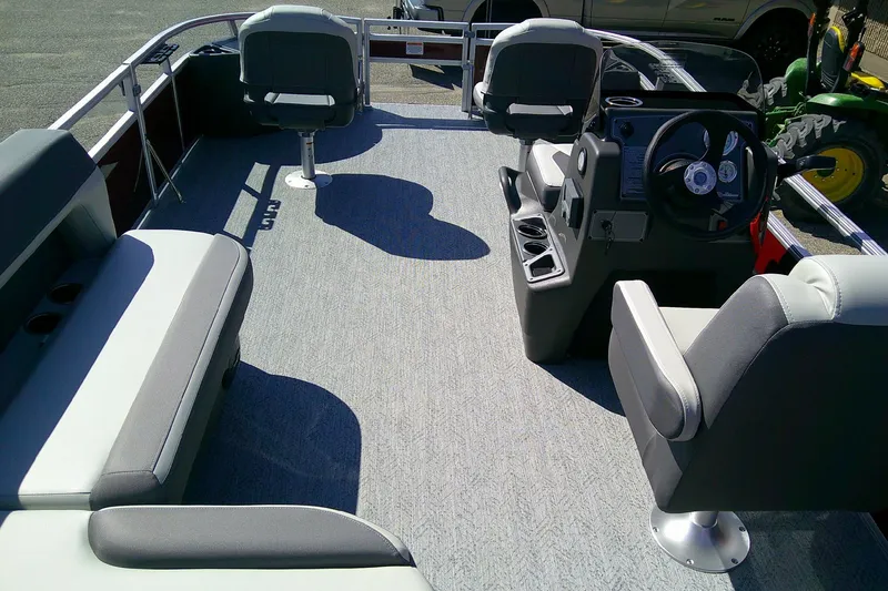 Slide: The Image of 2026 Sun Tracker Bass Buggy 18 DLX pontoon boat interior with seating and steering console. - 7
