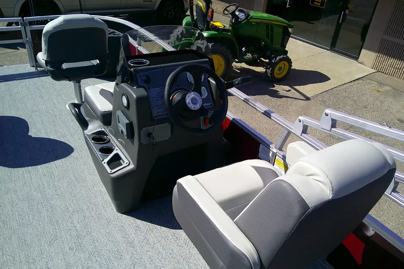 Slide: The Image of 2026 Sun Tracker Bass Buggy 18 DLX pontoon boat interior with steering console and seating. - 8