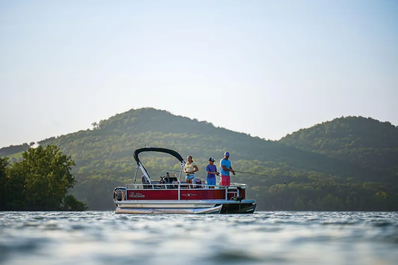 Slide: The Image of 2026 Sun Tracker Bass Buggy 16 XL Select pontoon boat on scenic lake with anglers fishing. - 74