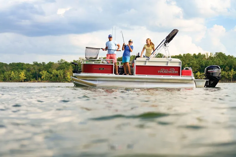 Slide: The Image of 2026 Sun Tracker Bass Buggy 16 XL Select pontoon boat on a scenic lake. - 77