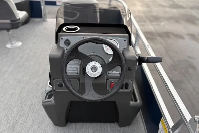 Slide: The Image of 2026 Sun Tracker Bass Buggy 18 DLX steering console with gauges and controls. - 16