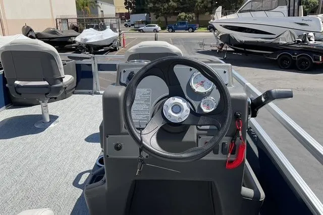 Slide: The Image of 2026 Sun Tracker Bass Buggy 18 DLX boat interior with steering wheel and gauges. - 13