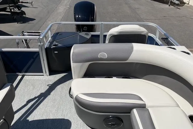 Slide: The Image of 2026 Sun Tracker Bass Buggy 18 DLX pontoon boat interior with cushioned seating and motor. - 16