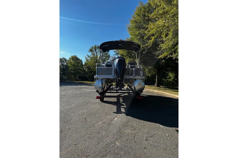 Slide: The Image of 2026 Sun Tracker Bass Buggy 18 DLX pontoon boat on trailer, parked outdoors. - 3