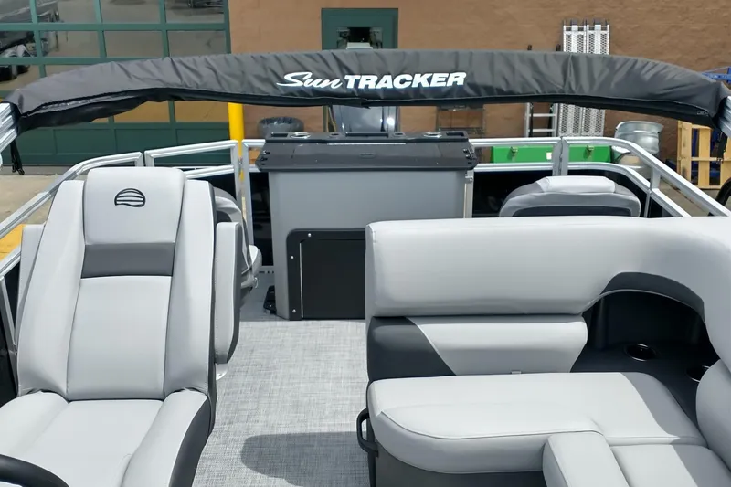 Slide: The Image of 2026 Sun Tracker SportFish 20 DLX pontoon boat on trailer in showroom. - 18