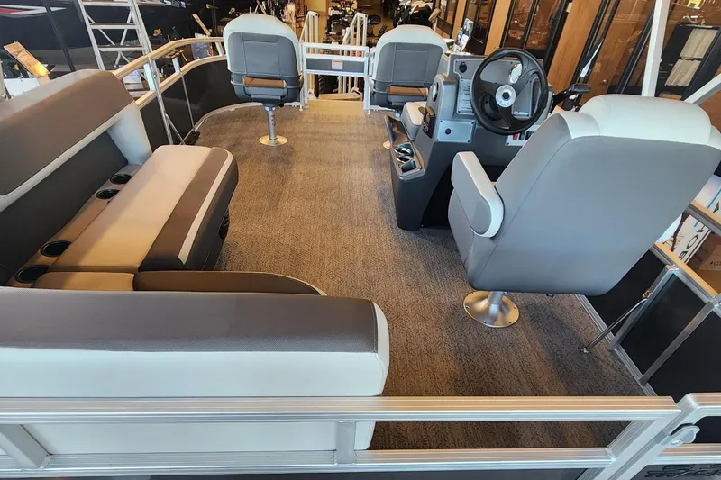 Slide: The Image of Interior of 2026 Sun Tracker Bass Buggy 16 XL Select pontoon boat with seating and steering console. - 2