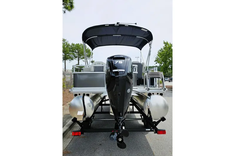 Slide: The Image of 2026 Sun Tracker Bass Buggy 18 DLX pontoon boat on trailer, parked outdoors. - 4