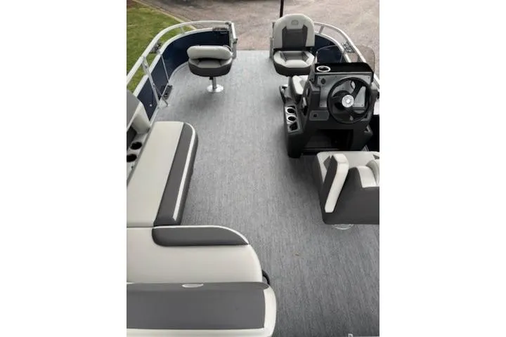 Slide: The Image of 2026 Sun Tracker Bass Buggy 18 DLX pontoon boat interior with seating and steering console. - 2