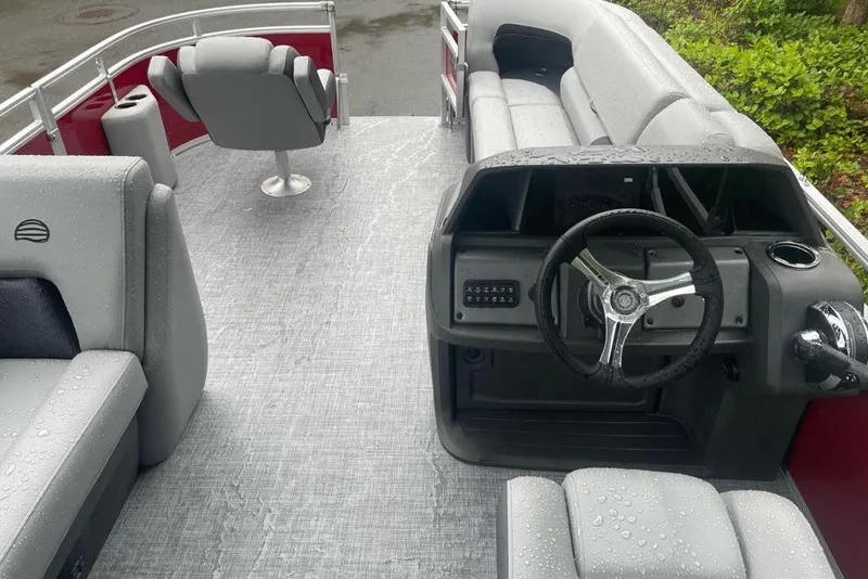 Slide: The Image of 2026 Sun Tracker SportFish 20 DLX pontoon boat interior with gray seating and steering console. - 69