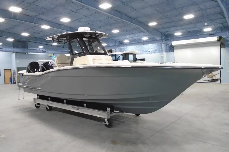 The Image of 2026 Scout 288 LXF boat in showroom, sleek design, dual engines, modern interior. - 1