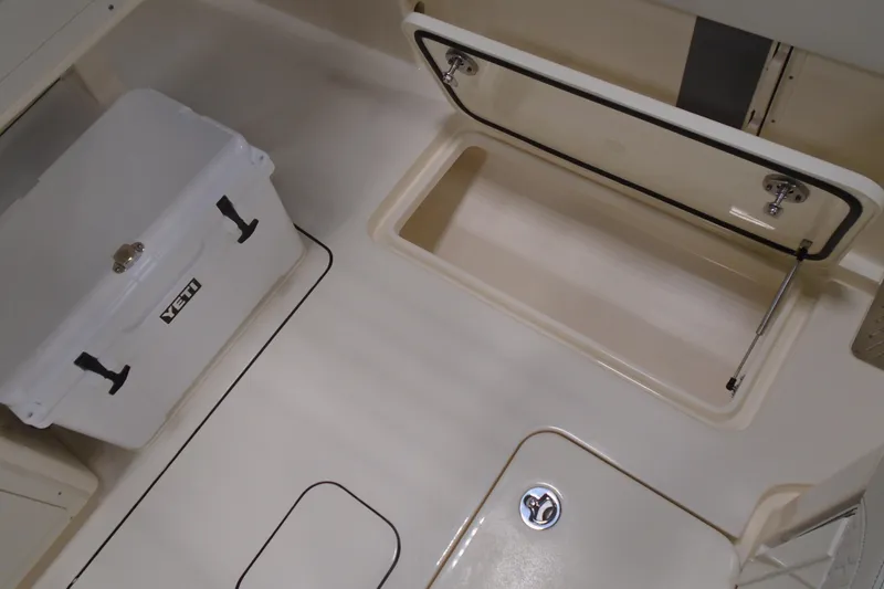 Slide: The Image of 2026 Scout 288 LXF boat interior with storage compartment and Yeti cooler. - 11
