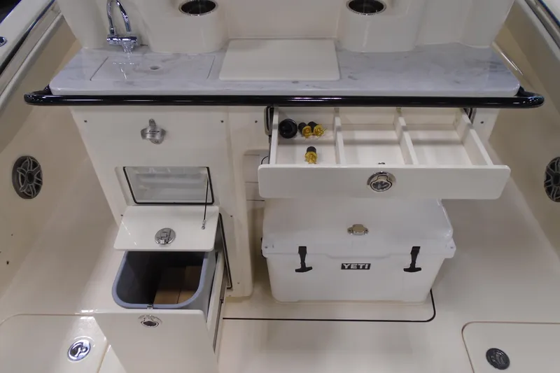 Slide: The Image of 2026 Scout 288 LXF boat interior with storage compartments and Yeti cooler. - 13