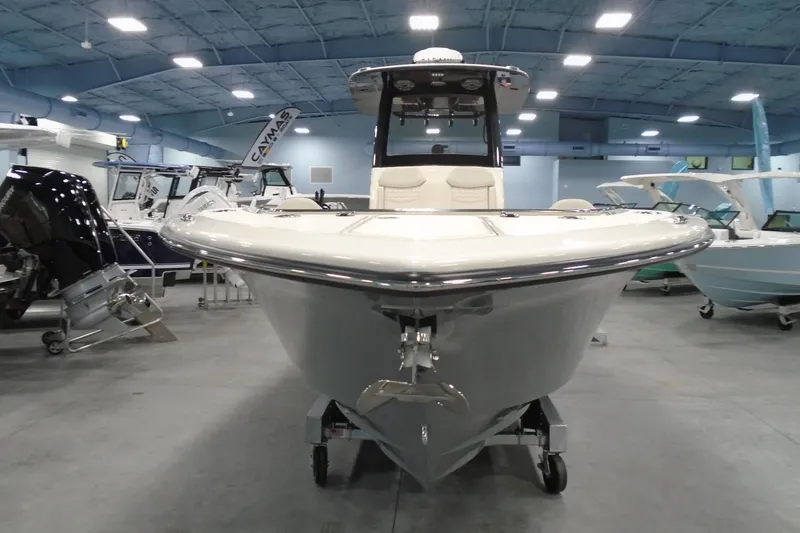 Slide: The Image of 2026 Scout 288 LXF boat displayed in a showroom with other boats. - 2