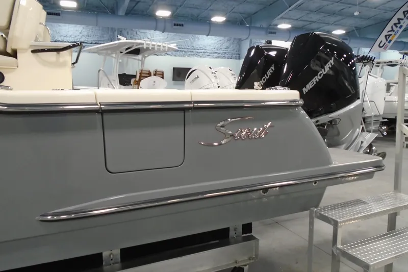 Slide: The Image of 2026 Scout 288 LXF boat with Mercury engines displayed indoors. - 3