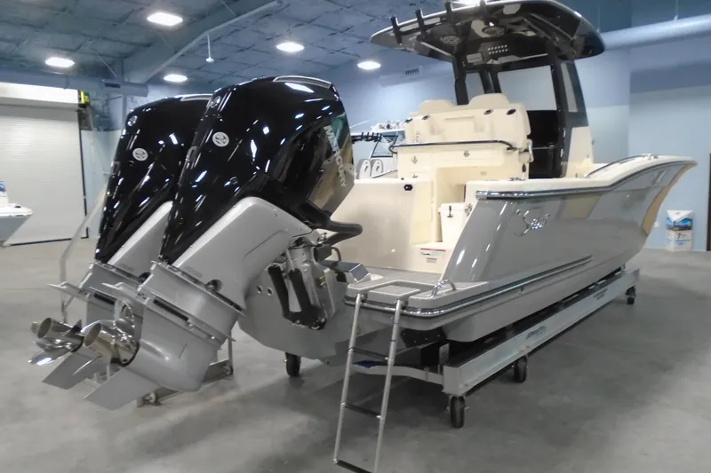 Slide: The Image of 2026 Scout 288 LXF boat with dual outboard engines in a showroom setting. - 4