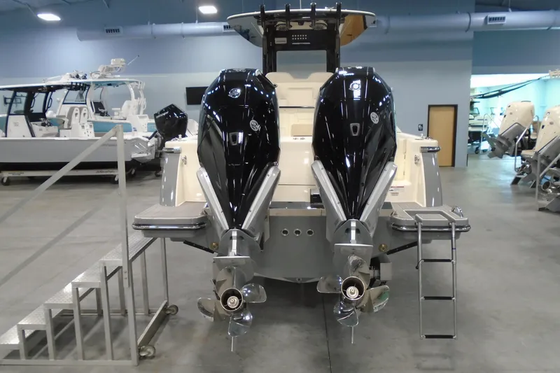Slide: The Image of 2026 Scout 288 LXF boat with dual outboard engines in showroom. - 5