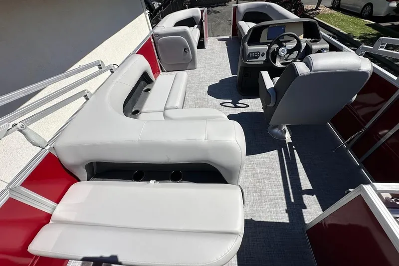 Slide: The Image of 2026 Sun Tracker Party Barge 18 DLX interior with gray seating and steering console. - 16