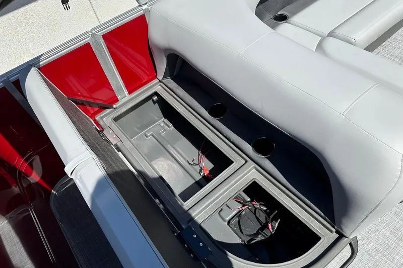 Slide: The Image of 2026 Sun Tracker Party Barge 18 DLX storage compartment with red and gray seating. - 29