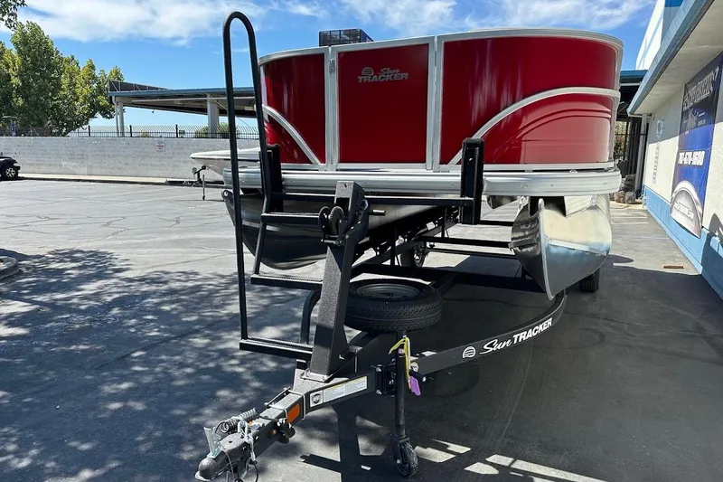 Slide: The Image of 2026 Sun Tracker Party Barge 18 DLX pontoon boat on trailer, parked outdoors. - 4