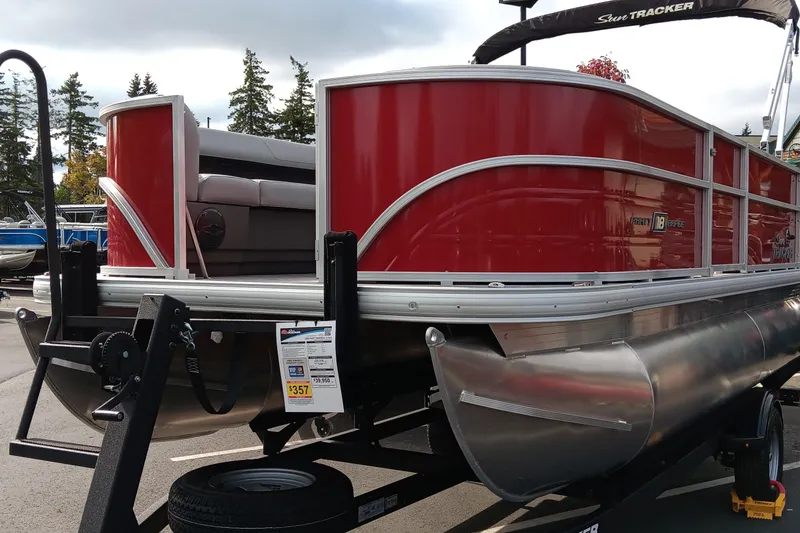 Slide: The Image of 2026 Sun Tracker Party Barge 18 DLX pontoon boat on trailer, red exterior. - 76