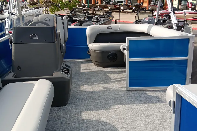 Slide: The Image of 2026 Sun Tracker Party Barge 16 DLX interior with blue and gray seating. - 2