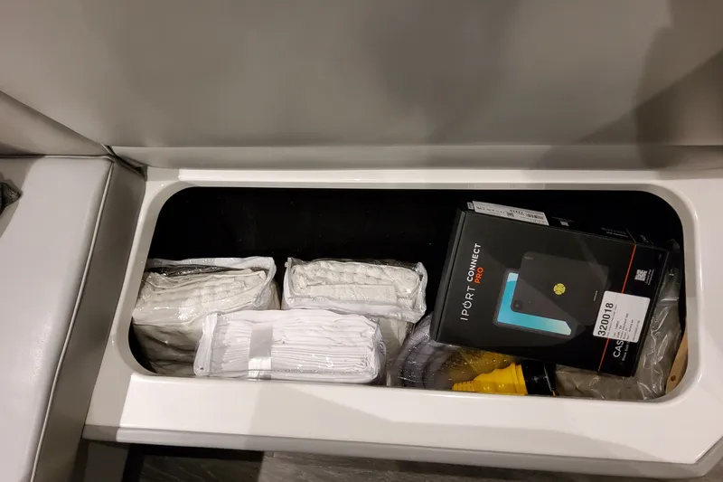 Slide: The Image of Storage compartment in a 2026 Formula 500 Super Sport Crossover with various items, including electronics. - 64