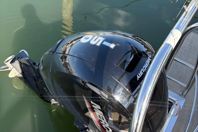 Slide: The Image of 2023 Harris Cruiser boat with Mercury outboard motor on calm water. - 2