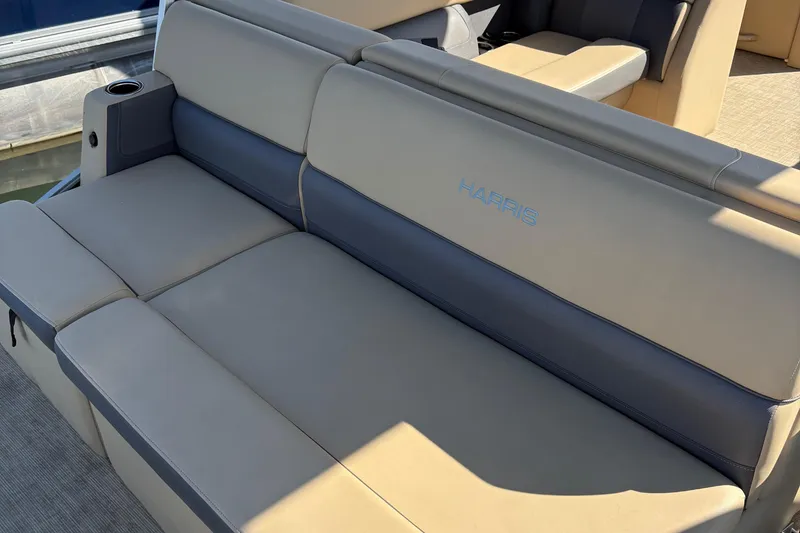 Slide: The Image of 2023 Harris Cruiser boat seating with beige and gray upholstery, featuring cup holders. - 3