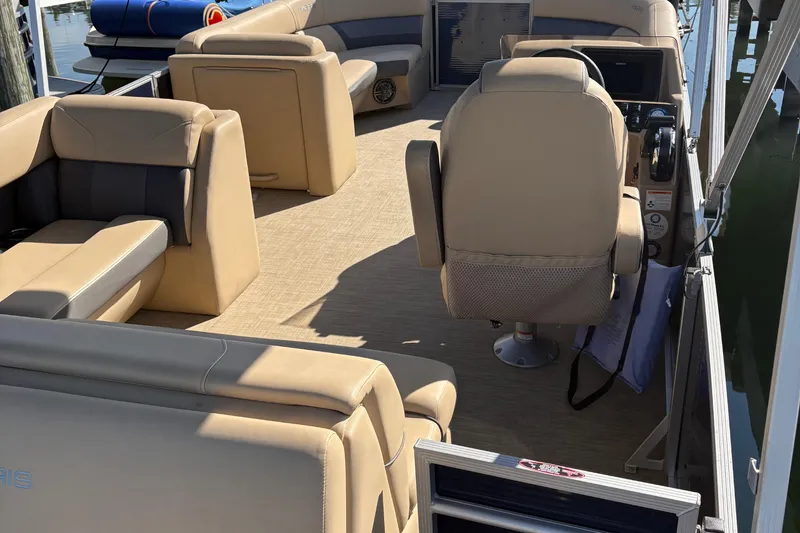 Slide: The Image of 2023 Harris Cruiser boat interior with beige seating and steering console. - 4