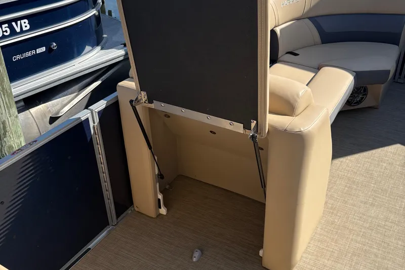 Slide: The Image of 2023 Harris Cruiser boat interior with beige seating and storage compartment. - 5