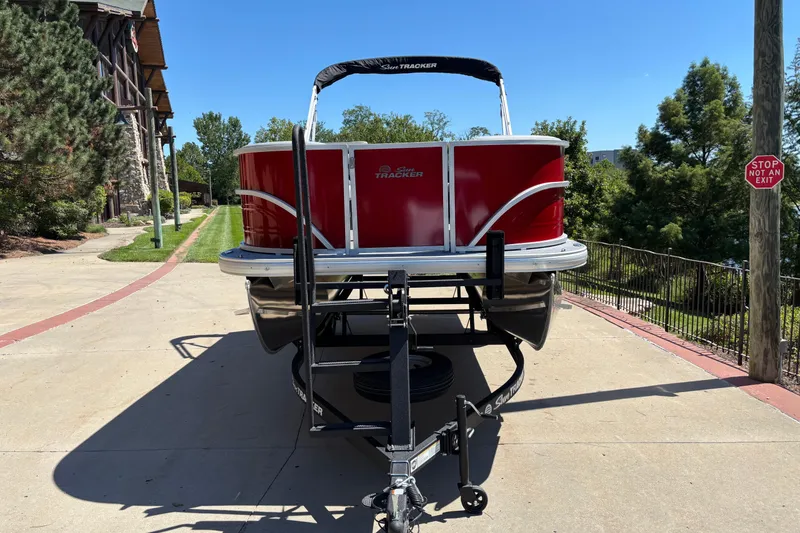 Slide: The Image of 2026 Sun Tracker Party Barge 18 DLX pontoon boat on trailer, parked outdoors. - 2