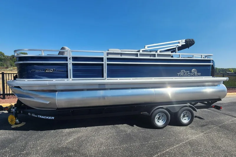 The Image of 2026 Sun Tracker SportFish 20 DLX pontoon boat on a trailer, side view. - 0