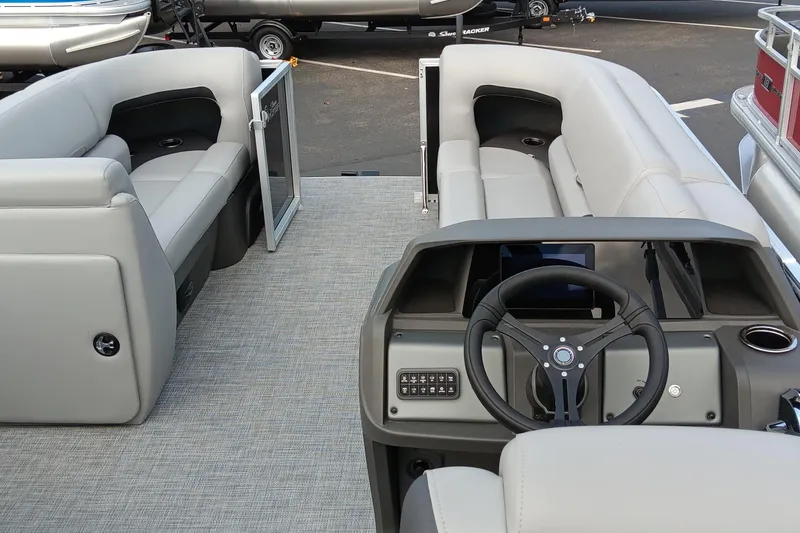 Slide: The Image of 2026 Sun Tracker Party Barge 20 DLX interior with plush seating and modern helm. - 2