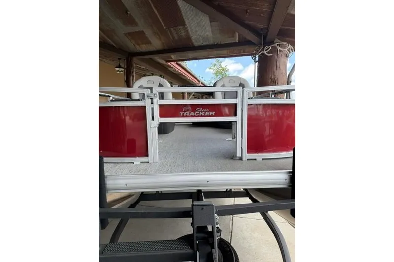 Slide: The Image of 2026 Sun Tracker Bass Buggy 16 XL Select pontoon boat in a covered area. - 4