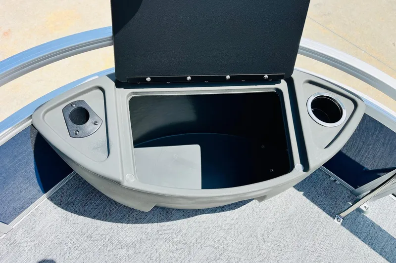 Slide: The Image of 2026 Sun Tracker Bass Buggy 18 DLX storage compartment with cup holders, open lid view. - 14