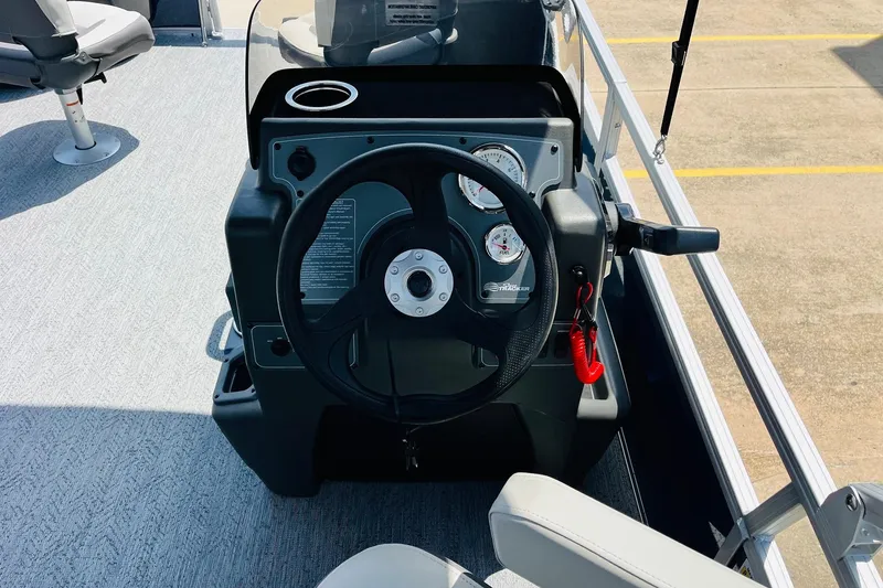 Slide: The Image of 2026 Sun Tracker Bass Buggy 18 DLX steering console with gauges and controls. - 23